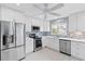 Well-lit kitchen with stainless steel appliances, white cabinetry, and decorative backsplash at 613 Chestnut Ln, Englewood, FL 34223