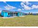 Charming blue home showcasing a screened lanai and expansive backyard, ideal for outdoor activities at 6264 Drucker Cir, Port Charlotte, FL 33981