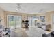 Bright living room with sliding glass doors to the backyard, desk, and dual ceiling fans at 6264 Drucker Cir, Port Charlotte, FL 33981