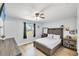 Cozy main bedroom with a large window, ceiling fan and wood-look flooring at 6264 Drucker Cir, Port Charlotte, FL 33981