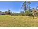 Spacious backyard featuring a grassy lawn, lush greenery, and a small decorative bench at 6699 San Casa Dr # Q3, Englewood, FL 34224