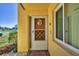 Close-up of a condo front door, with a decorative wreath and a welcome mat at 6699 San Casa Dr # Q3, Englewood, FL 34224
