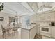 Bright kitchen and dining area with white cabinets, a chandelier, and sliding glass doors to the exterior at 6699 San Casa Dr # Q3, Englewood, FL 34224