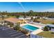 Aerial view of a community pool surrounded by a fence, parking, green space and lush landscaping at 6699 San Casa Dr # Q3, Englewood, FL 34224