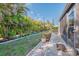 Lush backyard featuring tropical landscaping, a paver patio, and a well-maintained lawn at 6796 Gasparilla Pines Blvd # 40, Englewood, FL 34224