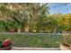 Relaxing backyard space surrounded by tropical plants, string lights, and a well manicured lawn at 6796 Gasparilla Pines Blvd # 40, Englewood, FL 34224