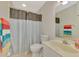 Bathroom featuring tile floors, vanity, toilet, and shower with striped curtain at 6796 Gasparilla Pines Blvd # 40, Englewood, FL 34224