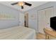 Bedroom with wood floors, ceiling fan, and closet with bi-fold doors at 6796 Gasparilla Pines Blvd # 40, Englewood, FL 34224