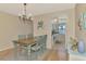 Dining room with view to kitchen area, featuring wood floors and seating for four at 6796 Gasparilla Pines Blvd # 40, Englewood, FL 34224