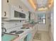 Bright kitchen features white appliances, tile flooring, and a view of the outdoors at 6796 Gasparilla Pines Blvd # 40, Englewood, FL 34224