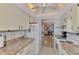 Bright kitchen with white cabinetry, stone countertops, and view to the living room at 6796 Gasparilla Pines Blvd # 40, Englewood, FL 34224