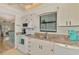 Bright kitchen with white appliances and cabinets, stone countertops, and view to the living room at 6796 Gasparilla Pines Blvd # 40, Englewood, FL 34224