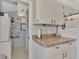 Kitchen countertop featuring dark hardware, with view to laundry area with shelves at 6796 Gasparilla Pines Blvd # 40, Englewood, FL 34224