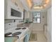 Bright kitchen features white appliances, tile flooring, and a view of the outdoors at 6796 Gasparilla Pines Blvd # 40, Englewood, FL 34224