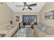 Bright living room features a fan, wood floors, seating, and view to screened-in patio at 6796 Gasparilla Pines Blvd # 40, Englewood, FL 34224
