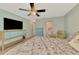 Cozy bedroom with wood floors, ceiling fan, television and view to the en-suite bathroom at 6796 Gasparilla Pines Blvd # 40, Englewood, FL 34224