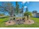 Entrance sign to Wildflower Village neighborhood showing landscaping and palm trees at 6796 Gasparilla Pines Blvd # 40, Englewood, FL 34224