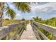 Picturesque boardwalk leading to the beach, framed by lush greenery at 7430 Palm Island Dr # 3813, Placida, FL 33946