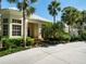 Charming single-story home with a well-manicured lawn, palm trees, and brick walkway at 790 N River Rd, Venice, FL 34293