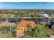Aerial view showcasing a home with a terracotta roof, three car garage, and waterside living at 8264 Antwerp Cir, Port Charlotte, FL 33981
