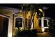 Beautiful home exterior features tropical landscaping, stone accents, and elegant outdoor lighting for nighttime appeal at 8264 Antwerp Cir, Port Charlotte, FL 33981