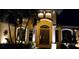 Elegant home entrance featuring a grand arched doorway, columns and well-maintained landscaping with subtle lighting at 8264 Antwerp Cir, Port Charlotte, FL 33981