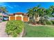 Charming home exterior with a terracotta roof, lush landscaping, and a paver driveway at 8264 Antwerp Cir, Port Charlotte, FL 33981