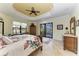 The primary bedroom features a decorative ceiling, tile floors, and sliding glass door to the pool at 8264 Antwerp Cir, Port Charlotte, FL 33981