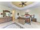 Spacious primary bedroom features tile floors, decorative furniture, and a tray ceiling with a fan at 8264 Antwerp Cir, Port Charlotte, FL 33981