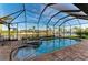 Inviting screened-in pool with spa, brick deck, and serene canal views at 8264 Antwerp Cir, Port Charlotte, FL 33981