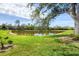 Large grassy backyard with mature trees and pond views at 8356 Creekview Ln, Englewood, FL 34224