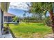 Pond view in backyard with mature landscaping, lush lawn and screened in patio at 8356 Creekview Ln, Englewood, FL 34224