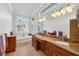 Bathroom featuring dual sinks, granite countertops, and a soaking tub with views at 8356 Creekview Ln, Englewood, FL 34224