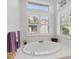 Bright bathroom featuring a soaking tub and neutral decor at 8356 Creekview Ln, Englewood, FL 34224