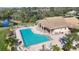 Aerial view of community pool with ample lounge seating, lush landscaping and shade at 8356 Creekview Ln, Englewood, FL 34224