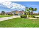 Charming single-story home with a well-manicured lawn, lush landscaping, and a paver driveway at 8356 Creekview Ln, Englewood, FL 34224