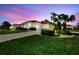 Charming single-story home features a tile roof, lush landscaping, and an attached two-car garage at 8356 Creekview Ln, Englewood, FL 34224