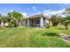 Exterior of house with lush green lawn, mature trees and screened in patio at 8356 Creekview Ln, Englewood, FL 34224