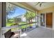Enclosed lanai with tile floor and view to backyard and palm trees at 8356 Creekview Ln, Englewood, FL 34224
