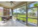 Enclosed lanai with tile floor and ceiling fan overlooking lake and landscaped backyard at 8356 Creekview Ln, Englewood, FL 34224
