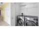 Laundry room featuring front load machines and storage shelves at 8356 Creekview Ln, Englewood, FL 34224
