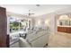 A well-lit living room showcases a ceiling fan, tile floors, and access to the screened lanai at 8356 Creekview Ln, Englewood, FL 34224