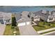Aerial view of a modern home with a three car garage and beautiful landscaping at 8562 Shore Lake Dr, Englewood, FL 34224