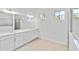Bathroom with a double vanity, large mirrors, tile floors, and natural light at 8562 Shore Lake Dr, Englewood, FL 34224