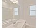 Clean, white bathroom with large mirror and natural light at 8562 Shore Lake Dr, Englewood, FL 34224