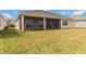 Back exterior view of the home showcasing the covered lanai and well-maintained lawn at 8562 Shore Lake Dr, Englewood, FL 34224