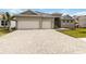 Charming single-story home featuring a large, three-car garage and beautiful front lawn at 8562 Shore Lake Dr, Englewood, FL 34224