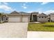 Charming single-story home featuring a large, three-car garage and beautiful front lawn at 8562 Shore Lake Dr, Englewood, FL 34224
