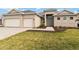 Charming single story home with a three-car garage, stone driveway, and mature landscaping at 8562 Shore Lake Dr, Englewood, FL 34224