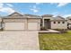 Charming single-story home featuring a large, three-car garage and beautiful front lawn at 8562 Shore Lake Dr, Englewood, FL 34224